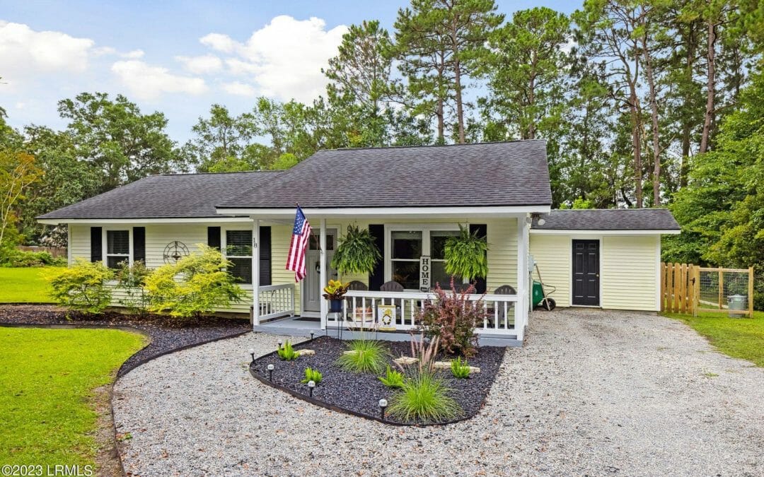 A white house with a flag on the front porch.
